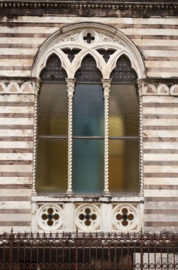 A fragment of an old chapel window in the old Florentine cemetery. Cimitero delle Porte Sante (The Sacred Doors Cemetery) , Florence, Italy clipart