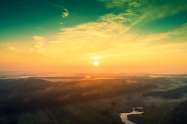 Rural landscape in the evening with the dramatic evening sky. Aerial view. View from above of the countryside during sunset