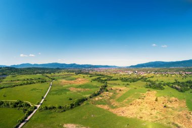 Drone view of the countryside. Road, meadows, and the village in the foothills of the Carpathians