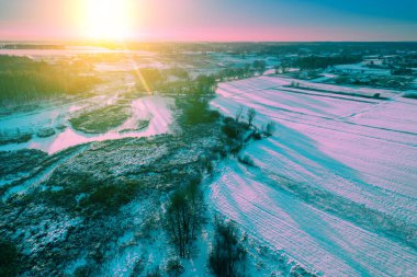 Köyde bir akşam. Tarıma elverişli alan karla kaplı. Sihirli ışık ile manzara