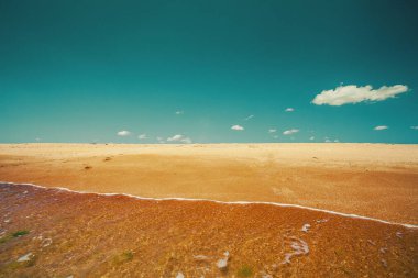 Güneşli bir günde deniz manzarası. Kumsalda mavi gökyüzü