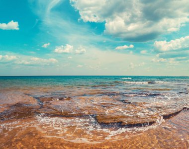 Güzel bulutlu gökyüzü olan deniz manzarası. Kaya sahili.