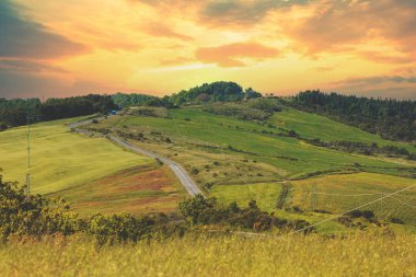 Güzel bahar manzarası. Güneşli bir günde dağlarla ve vadilerle manzara. Tuscany, İtalya 'nın yuvarlanan tepelerindeki güneşli tarlaların manzarası