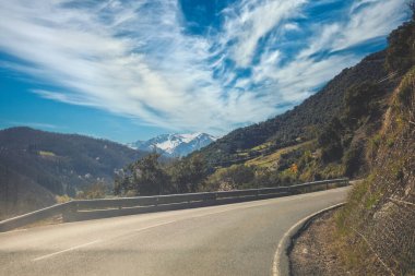 Güneşli bir günde ilkbaharın başlarında güzel bir dağ manzarası. Ön camdan bir bak. Ulusal Park Picos de Europa 'da bir dağ yolunda araba kullanmak. Cantabria, İspanya, Avrupa;