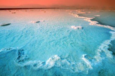 Ölü Deniz 'in dokusu. Güneş doğarken tuzlu deniz kıyısında