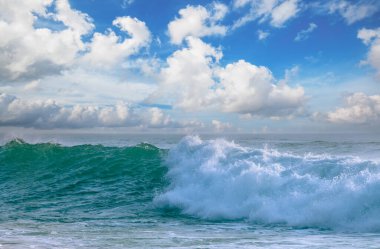 Dalgalar kayalık sahilde yuvarlanıyor