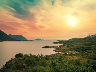 Akşamları dağ kıyısında. Gün batımında fiyort manzarası. Norveç 'in güzel doğası