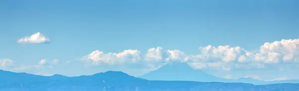Silhouette of a mountain ridge against the sky.  Horizontal banner