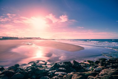 Akşamları deniz manzarası dalgalı olur. Costa da Caparica 'nın deniz kıyısında gün batımında. Portekiz