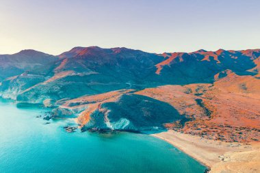 Dramatik bir günbatımı gökyüzüne sahip kayalık bir sahil şeridi manzarası. Akşamları deniz manzarası. Doğal Rezerv Cabo de Gata-Njar. Almerya, Endülüs, İspanya