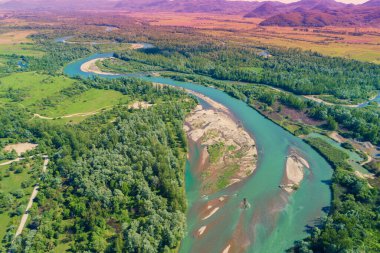 Winding river in the valley on a sunny day. Panoramic view from above of mountain valley. Nature landscape. Tisza river, Zakarpattia Oblast, Ukraine