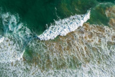 Okyanus sörfü. Dalgalar kıyıya vuruyor. Yukarıdan bak. Doğal soyut arkaplan