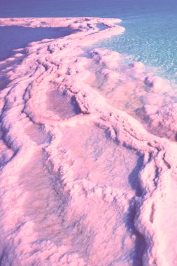 Gün doğumunun pembe ışığında Ölü Deniz 'in dokusu. Tuzlu deniz kıyısı. Soyut doğa arkaplanı
