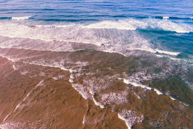 Okyanus sörfü. Dalgalar kıyıya vuruyor. Yukarıdan bak. Doğal soyut arkaplan