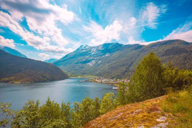 View of Geirangerfjord on a sunny day. Beautiful waterfront of Hellesylt cruise port, Norway clipart