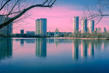 Kyiv sabah. Dinyeper Nehri 'nin sol kıyısında. Akşamları ağaçlı Lakeshore. Göldeki binaların güzel yansıması