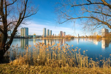 Skyline, Kyiv şehri, sabah. Dinyeper Nehri 'nin sol kıyısında. Sabahları ağaçlı Lakeshore. Göldeki binaların güzel yansıması