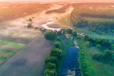 Gölün üzerinde sihirli gün doğumu. Puslu bir sabah, kırsal alan, vahşi doğa, mistik bir his. Sihirli ışıkta huzur gölü