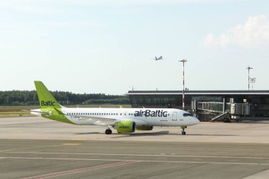 Riga, Letonya - 26 Mayıs 2024: Lidosta havaalanında Hava Baltık uçağı. Air Baltic, merkezi Riga Uluslararası Havaalanı 'nda bulunan Letonya' nın bayrak taşıyıcısıdır.
