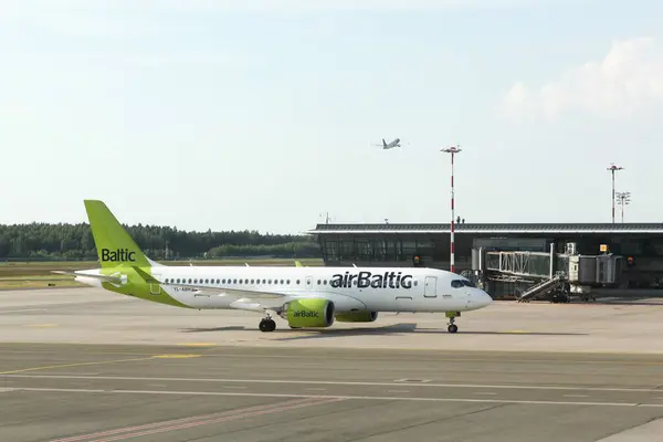 stock image Riga, Latvia - May 26, 2024: Air Baltic aircraft at Lidosta airport. Air Baltic is the flag carrier of Latvia, with its head office on the grounds of Riga international airport