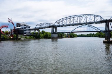 Nashville, Tennessee USA - May 9, 2022: Downtown cityscape along the Cumberland River with the John Seigenthaler Pedestrian Bridge