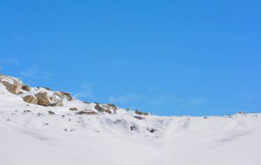Karla kaplı taşlar ve mavi gökyüzü