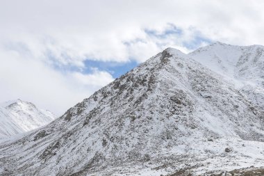 Karla kaplı taşlar ve mavi gökyüzü.