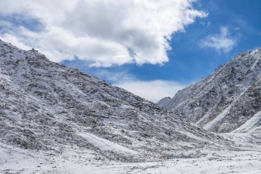 Karla kaplı taşlar ve mavi gökyüzü.
