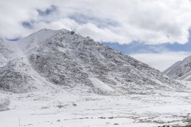 Karla kaplı taşlar ve mavi gökyüzü.