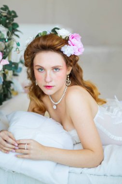 Beyaz elbiseli güzel gelin stüdyoda poz veriyor.