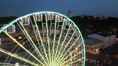 Dönme dolap günbatımı gecesi LED neon ışıkları Kyiv Ukrayna İHA 'sı havada uçuşuyordu. Yüksek kalite 4k görüntü