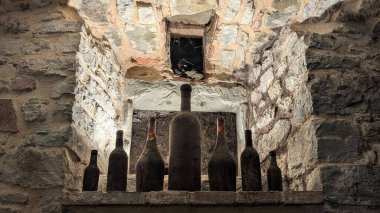 Tuscany, İtalya 'da eski şarap şişeleriyle dolu antik şarap mahzeni.