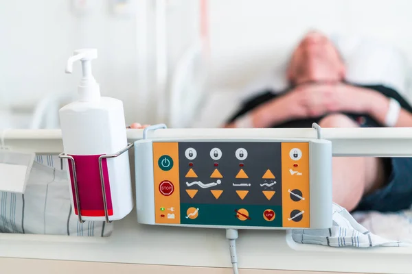 病院のベッドのリモートコントローラは 悪いの位置を調整し ベッドに患者を敷設 — ストック写真