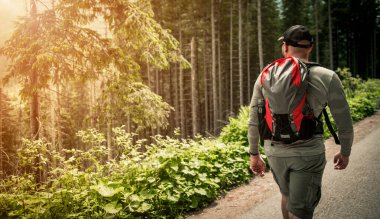 Orman gezisi sırasında profesyonel olarak giyinmiş bir yürüyüşçü. Spor ve eğlence teması.
