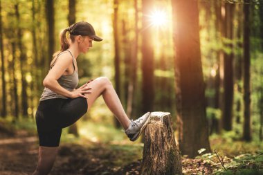 Ormanda koşuyor. Genç bayan koşucu ormanda koşmadan önce esniyor..