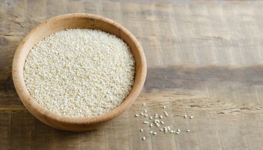 Sesame seeds in a wooden bowl on a table. Concept of healthy eating. Horizontal orientation.