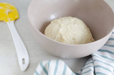 Masada hamurlu bir kase ve spatula var. Borç için Pampushky, geleneksel Ukrayna çörekleri yapma süreci. Geleneksel yemek kavramı. Ev yapımı pişirme. Yatay yönelim