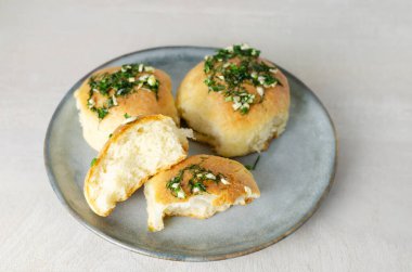 Sarımsaklı üç çörek ve gri tabakta yağlı dereotu sosu. Borş için geleneksel Ukrayna çörekleri olan pampushky (Pampushky) hazırlığı. Geleneksel yemek kavramı. Ev yapımı pişirme..