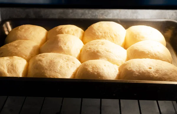 The process of baking buns in the oven. Preparation of pampushky (Pampushky), traditional Ukrainian buns for borsch. The concept of traditional dishes. Homemade baking. Horizontal orientation.