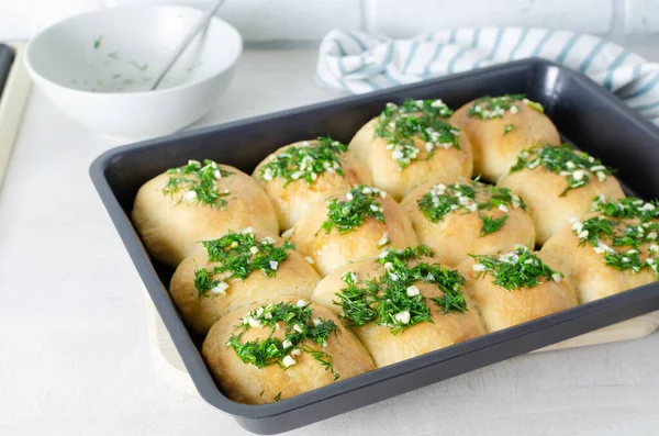 stock image Buns with garlic and dill sauce with oil. Preparation of pampushky (Pampushky), traditional Ukrainian buns for borscht. The concept of traditional dishes. Homemade baking. Horizontal orientation.