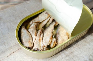 Ahşap bir masada konserve balık. Konserve balık konsepti. Kırsal tarzda. Yatay yönelim.