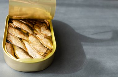Gri arka planda konserve balık. Konserve balık konsepti. Yatay oryantasyon. Boşluğu kopyala.