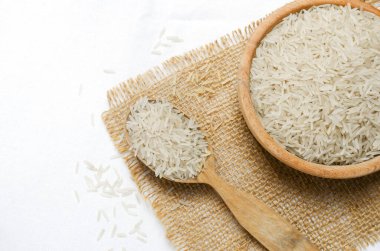 Tahta kaşıkta çiğ basmati pilavı ve çuval bezinde bowling. Su tasarrufu ürünleri kavramı. Su tasarrufu. Yatay oryantasyon. Üst Manzara. Boşluğu kopyala.