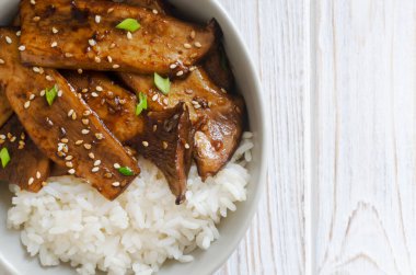 Susamlı, yeşil soğanlı ve gri kasede kaynamış pirinçli eryngii mantarı. Gochujang Kral İstiridye Mantarı Bulaşıkları. Geleneksel Kore mutfağı. Uzayı kopyala Üst görünüm