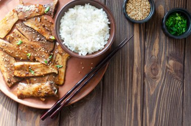 Seramik tabakta susam ve yeşil soğanla kızartılmış eryngii mantarı ve bir kasede kaynatılmış pirinç. Gochujang Kral İstiridye Mantarı Bulaşıkları. Kore mutfağı. Kırsal tarzda. Üst Manzara. Boşluğu kopyala