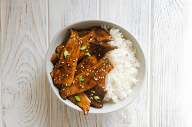 Susamlı, yeşil soğanlı ve gri kasede kaynamış pirinçli eryngii mantarı. Gochujang Kral İstiridye Mantarı Bulaşıkları. Geleneksel Kore mutfağı. Yatay oryantasyon. Üst görünüm