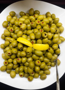 Beyaz tabakta limon dilimli tuzlu zeytin. Türkiye 'de her şeyi kapsayan açık büfe tarzı gıda kavramı. Çeşitli zeytin çeşitleri olan bir yer. Dikey oryantasyon. Seçici odaklanma. Üst görünüm