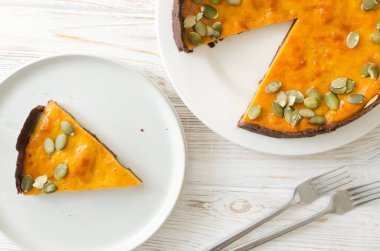 Masasında çatallar olan beyaz bir tabakta kurutulmuş tohumlu turta. Sonbahar havası. Çay saati konsepti. Yatay oryantasyon. Üst görünüm.