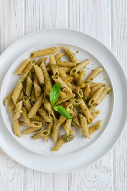 Fındık ezmeli makarna. Masada çatal ve beyaz bir tabakta fesleğen var. İtalyan mutfağı konsepti. Yatay oryantasyon. Seçici odaklanma. Üst görünüm.