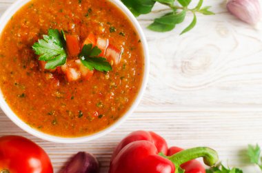 Soğuk yaz çorbası Gazpacho beyaz kâse içinde malzemeler masada. Geleneksel İspanyol mutfağı. Vejetaryen ya da vejetaryen. Seçici odaklanma. Yatay oryantasyon. Üst Manzara. Boşluğu kopyala.